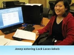 Jenny smiling at a desk with a computer.