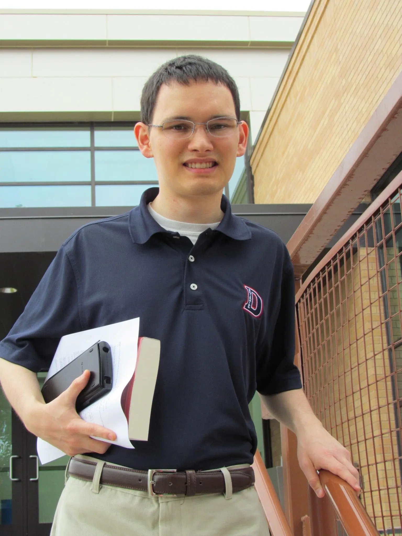 Joshua holding a book and phone.