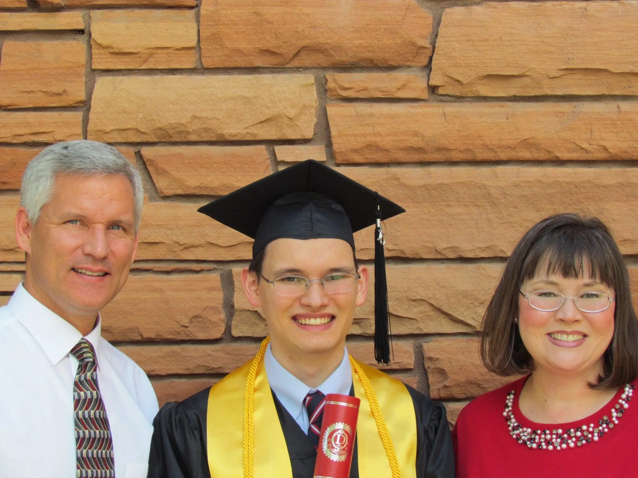 Joshua with his parents on graduation day.