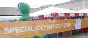 Banner reads "Special Olympics Town" next to an inflatable alien figure.