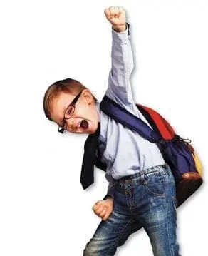 A boy with glasses and a backpack cheers with his fist raised.