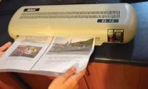 A laminator with two pages being fed into it.