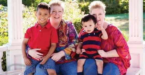 Two women and two young boys posing for a photo.