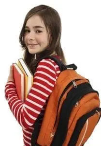 Young girl with backpack and books smiling.