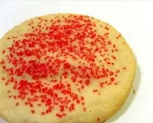 Rolled sugar cookie with red sprinkles.