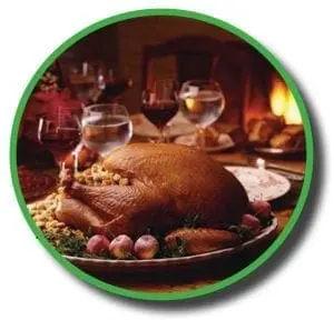 A roasted Thanksgiving turkey on a platter with grapes and stuffing.