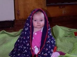 Caitlyn wrapped in a patterned blanket.