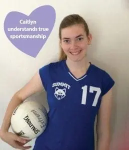 Caitlyn in a blue volleyball jersey holding a volleyball.
