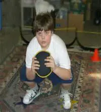 Child performing a sandbell squat.