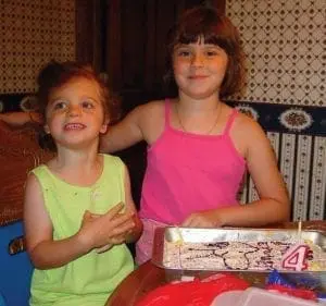 Michele Gianetti's daughters with a birthday cake.