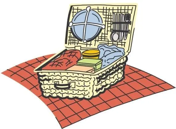 Picnic basket filled with food and utensils on a checkered blanket.