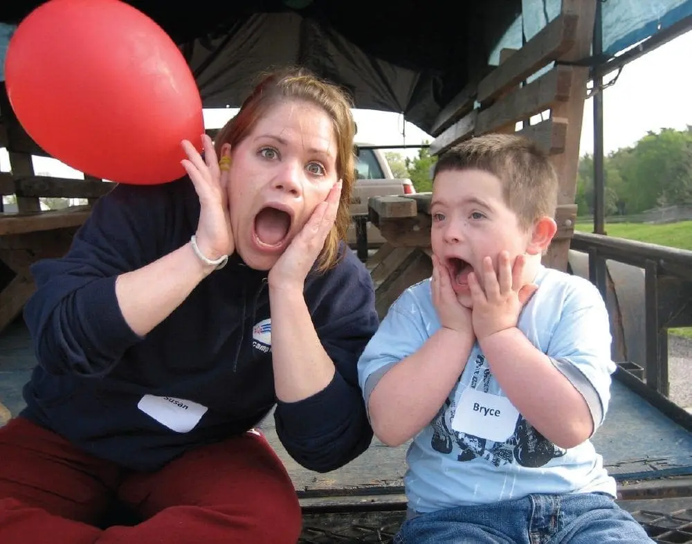 Two people with hands on their faces and mouths open in surprise.