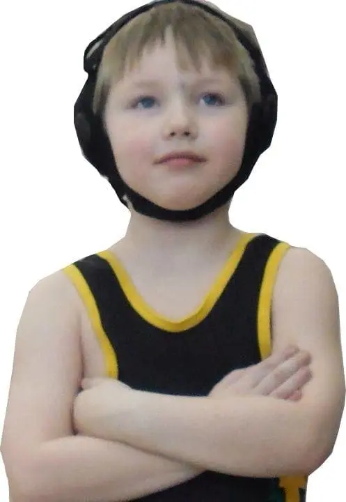 Young child wearing wrestling headgear and a singlet with arms crossed.