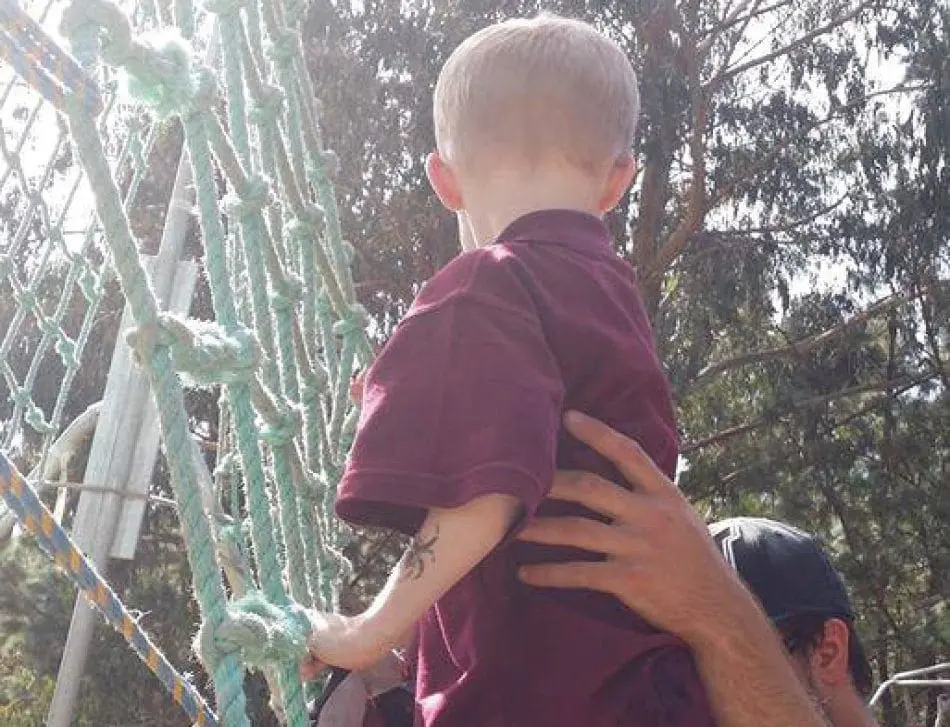 Jordan Cook climbing a rope structure.