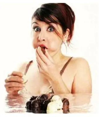 Woman with stuffed cheeks eating chocolate cake.