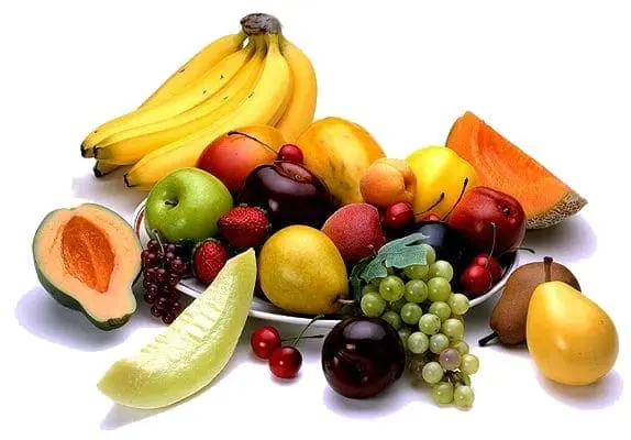 A variety of fresh fruits including bananas, apples, plums, grapes, strawberries, and melon slices.