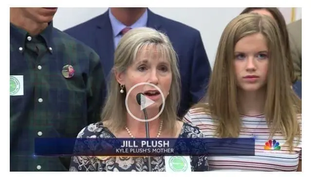 Jill Plush, Kyle Plush's mother, speaks at a podium.
