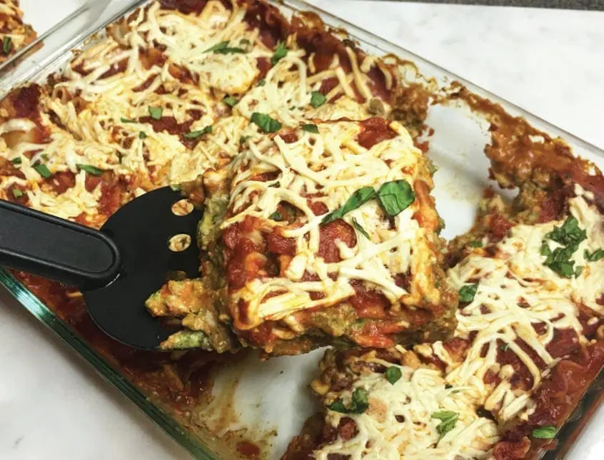 Gluten and dairy free lasagna in a baking dish with a serving removed.