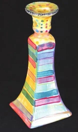 Ceramic candlestick with colorful stripes and polka dots.