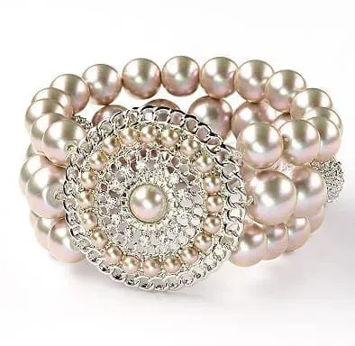 Silver tone stretch bracelet with simulated pearls and a round decorative clasp.