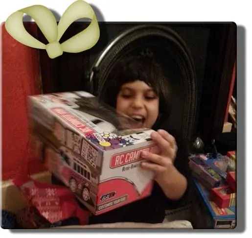 A child excitedly holds an RC camera gift box.