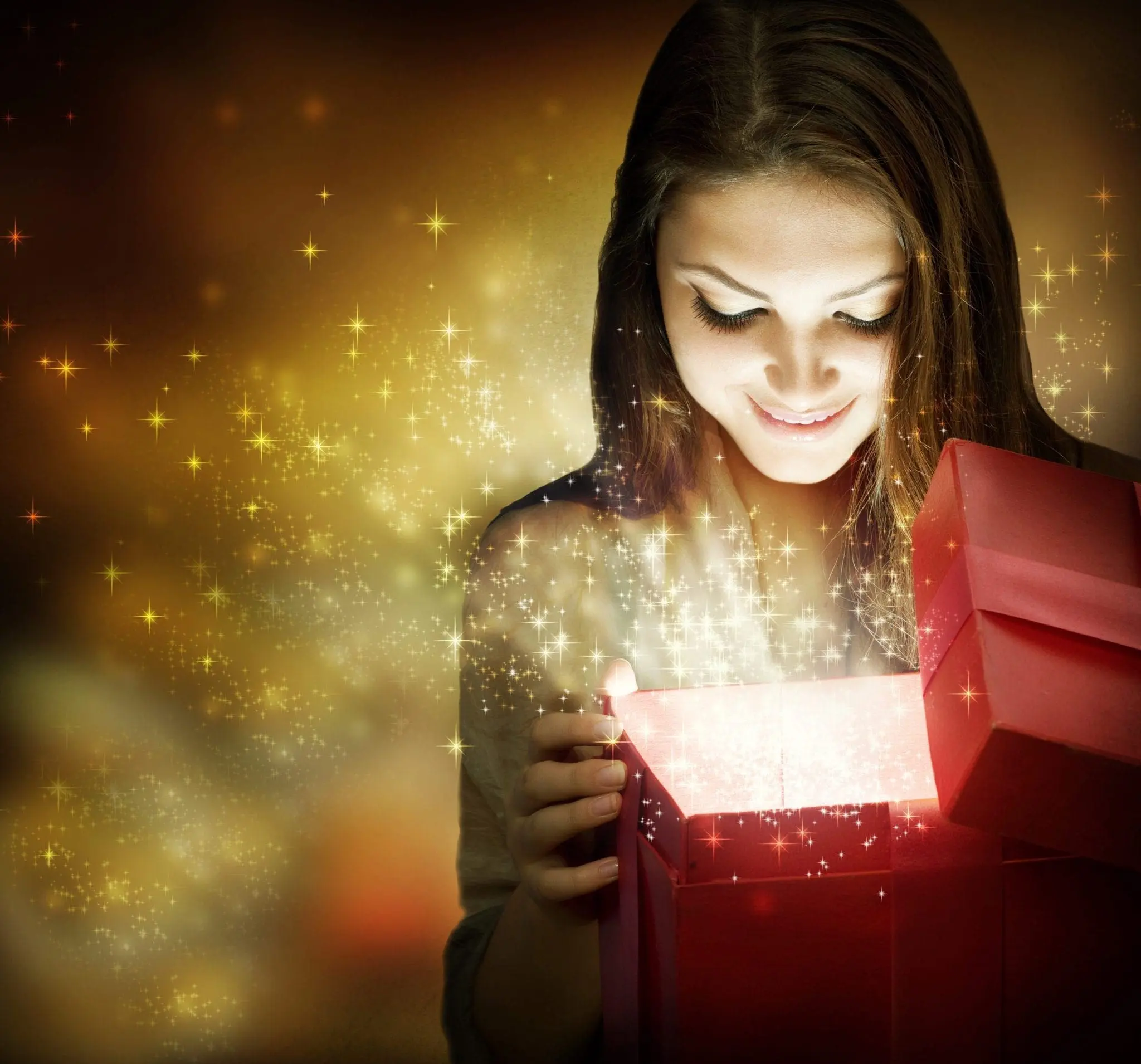 A woman opens a glowing gift box surrounded by golden sparkles.