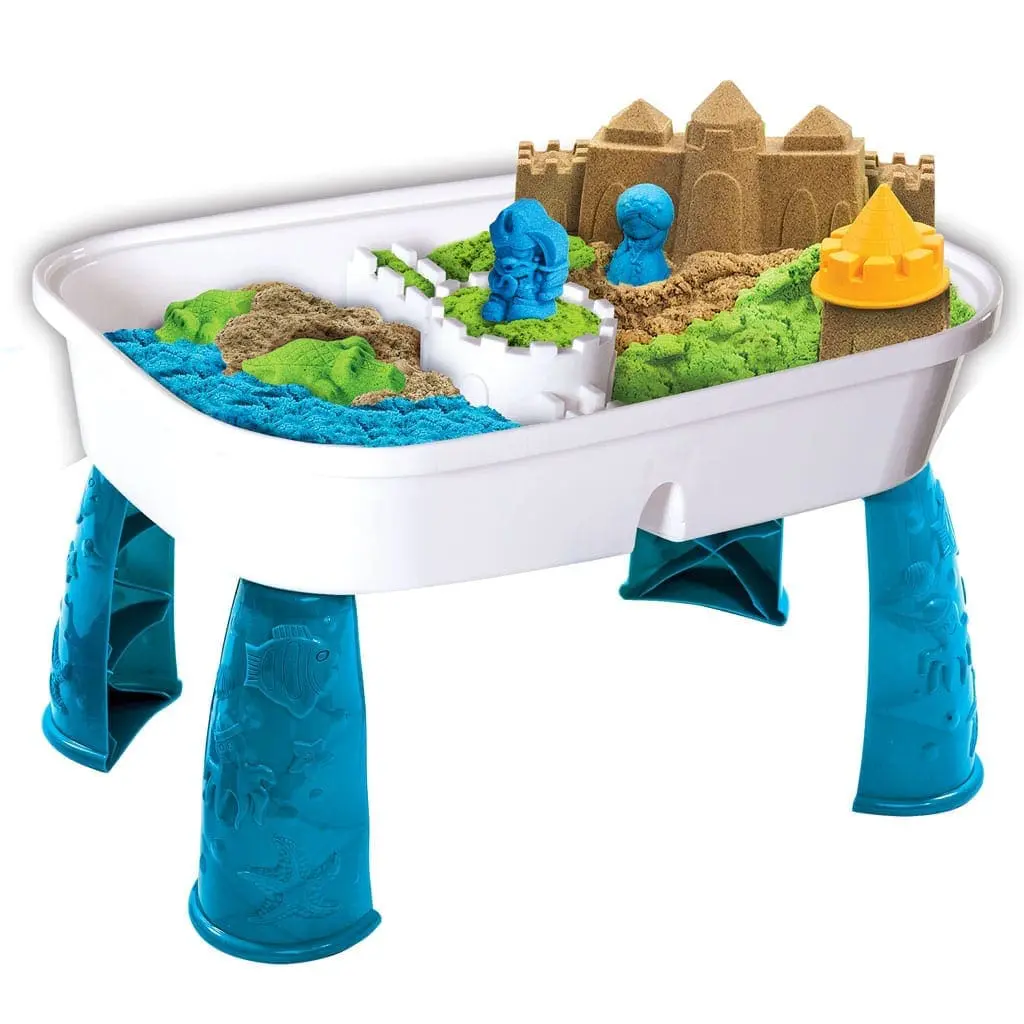 Kinetic sand activity table with blue legs and sandcastles.