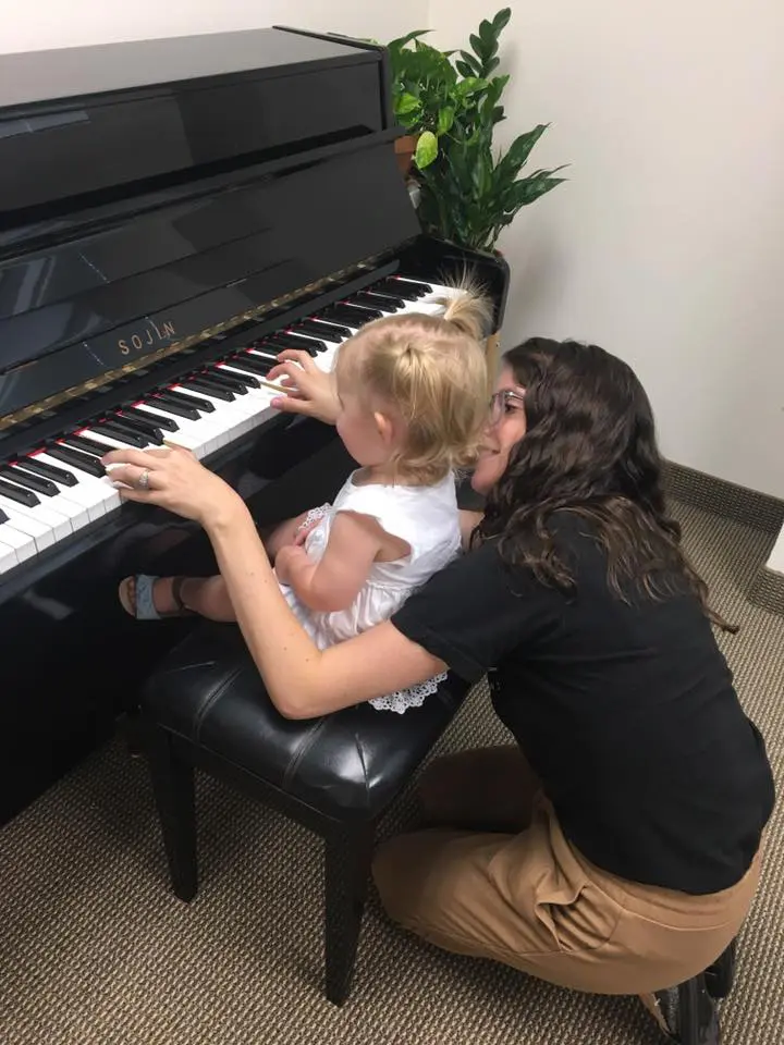 A woman and a young child play the piano at Octopus Music School.