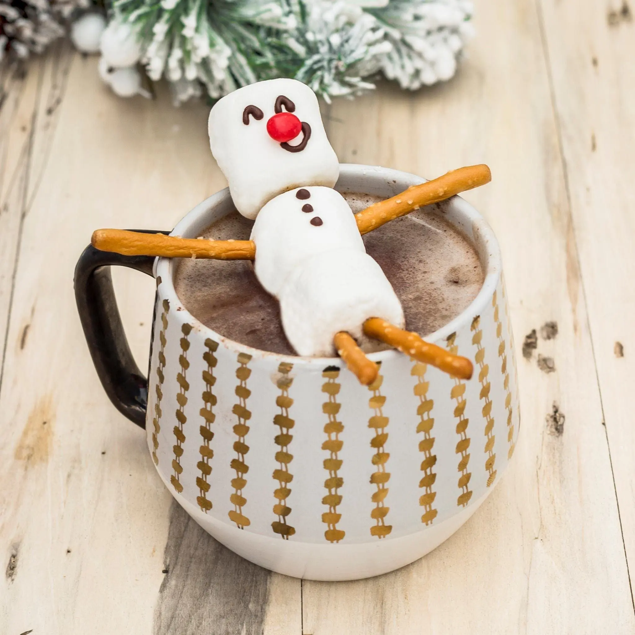 Marshmallow snowman relaxing in a mug of hot chocolate.