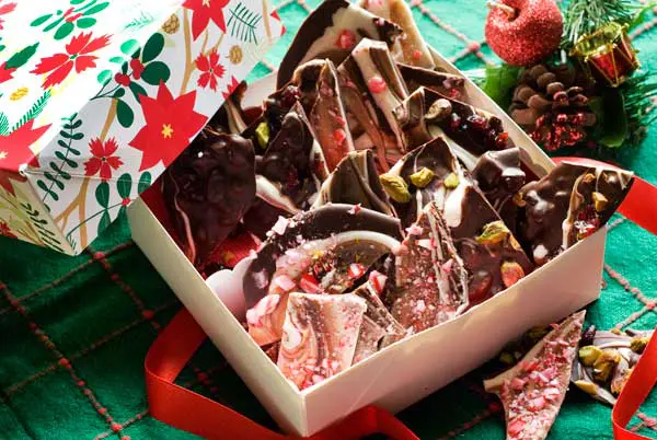 Gluten-free Christmas bark in a box with holiday decorations.