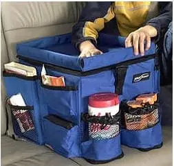 A blue car organizer with many pockets sits on a car seat, holding various items.