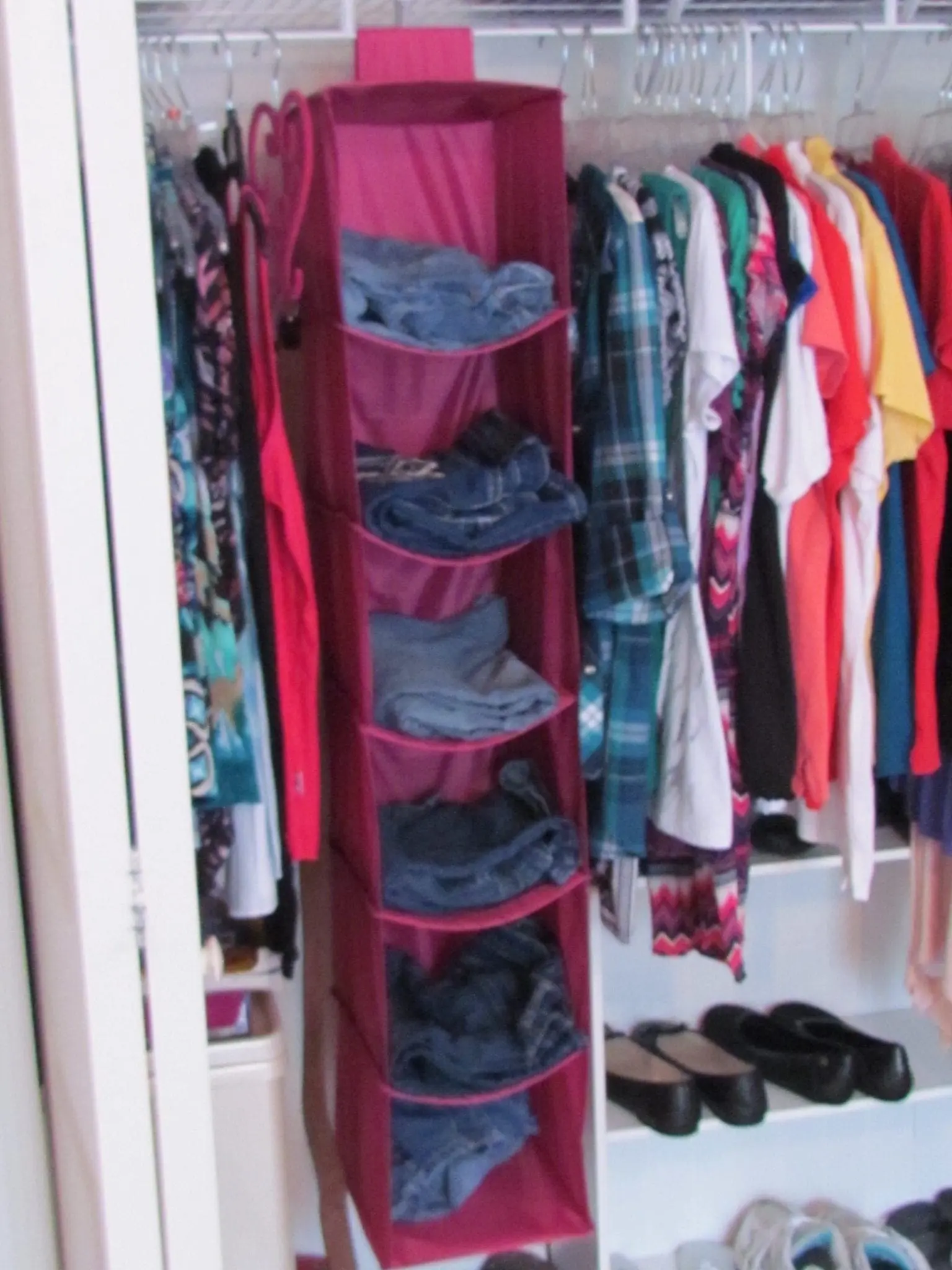 Six shelf closet space saver holding folded clothing.