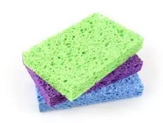 Three cleaning sponges stacked on a white surface.
