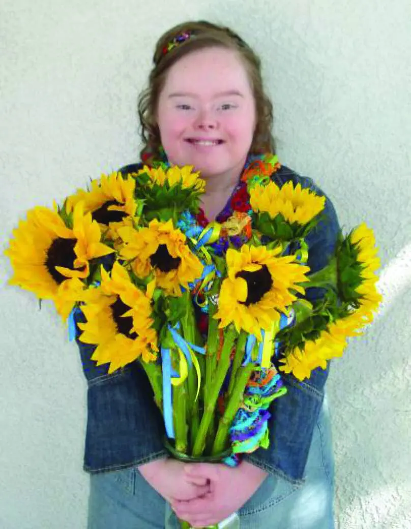 Amber holding a bouquet of sunflowers.