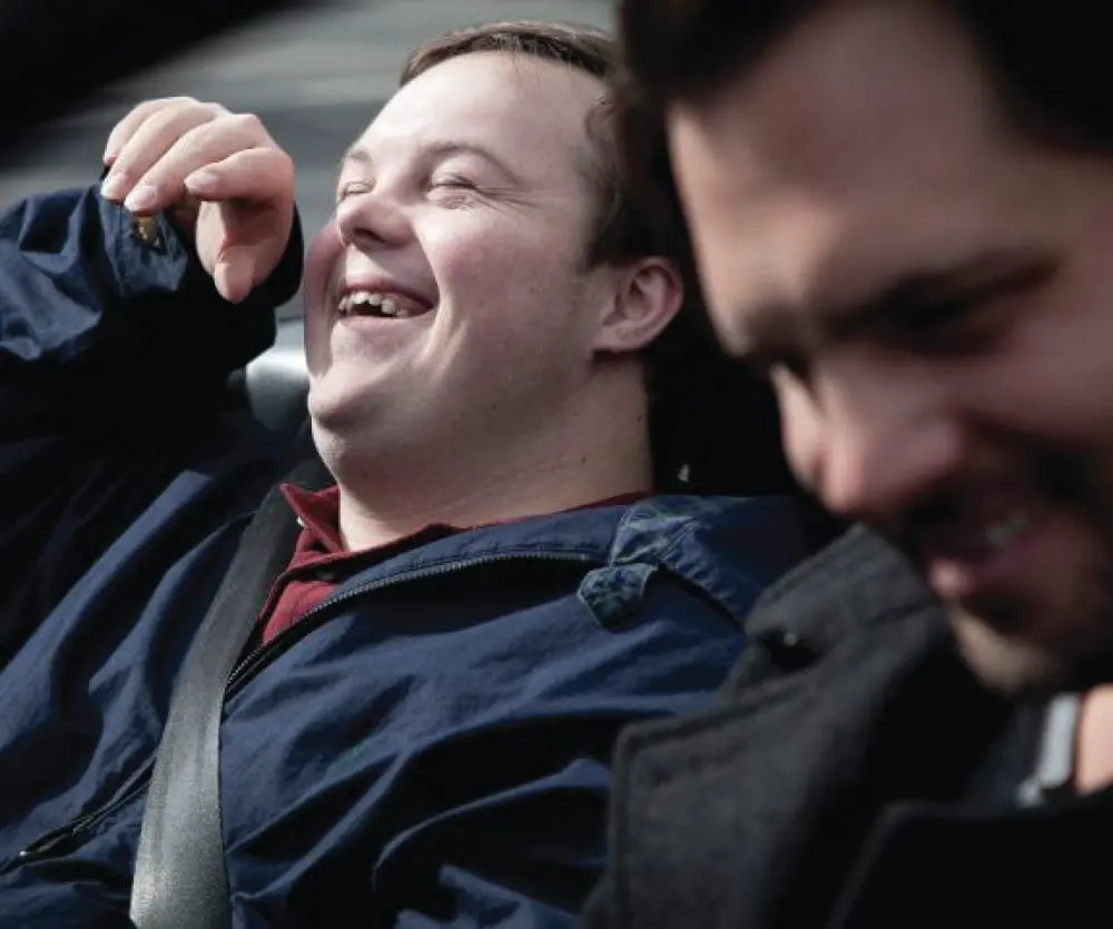 Two men laughing in a car.