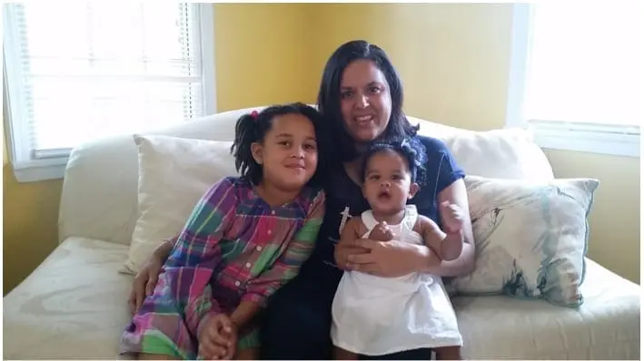 Meirva and Salome with their mother on a couch.