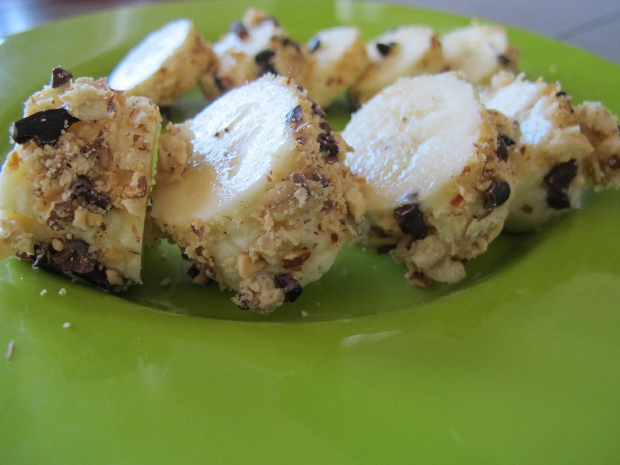 Banana sushi rolls on a green plate.