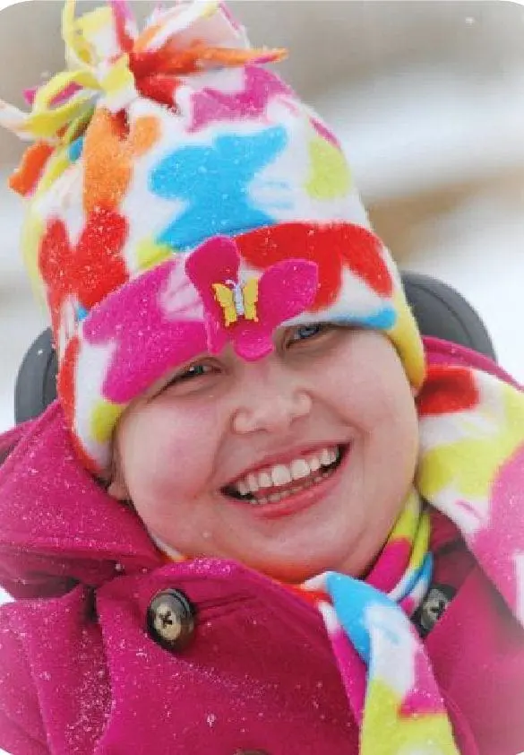 Cortney Kovack smiling in a colorful winter hat and scarf.