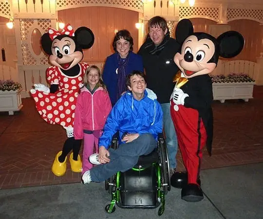 Julie Jones poses with family and Mickey and Minnie Mouse characters at night