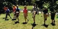Several people exercising on a grassy field outdoors