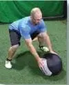 Man performing a frog hop with a medicine ball