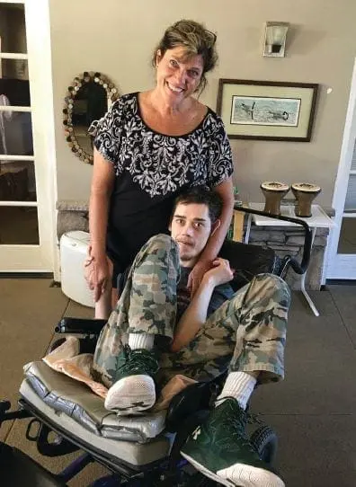 Cathy Hilling embraces Wesley as they sit in a wheelchair.