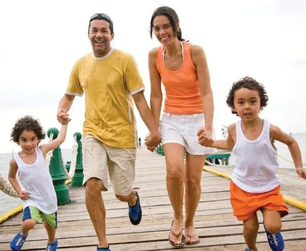 Family running on a wooden pier.