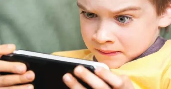 A boy engrossed in a smartphone game.