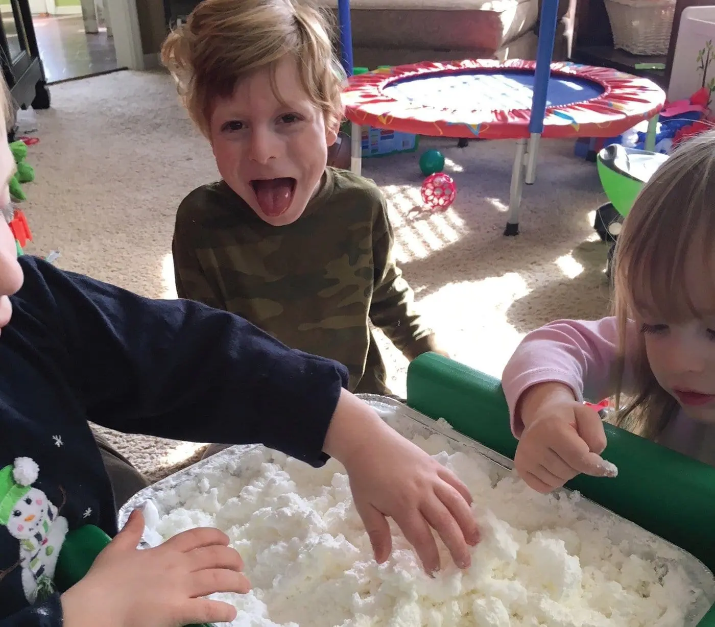 Three children play with homemade snow.