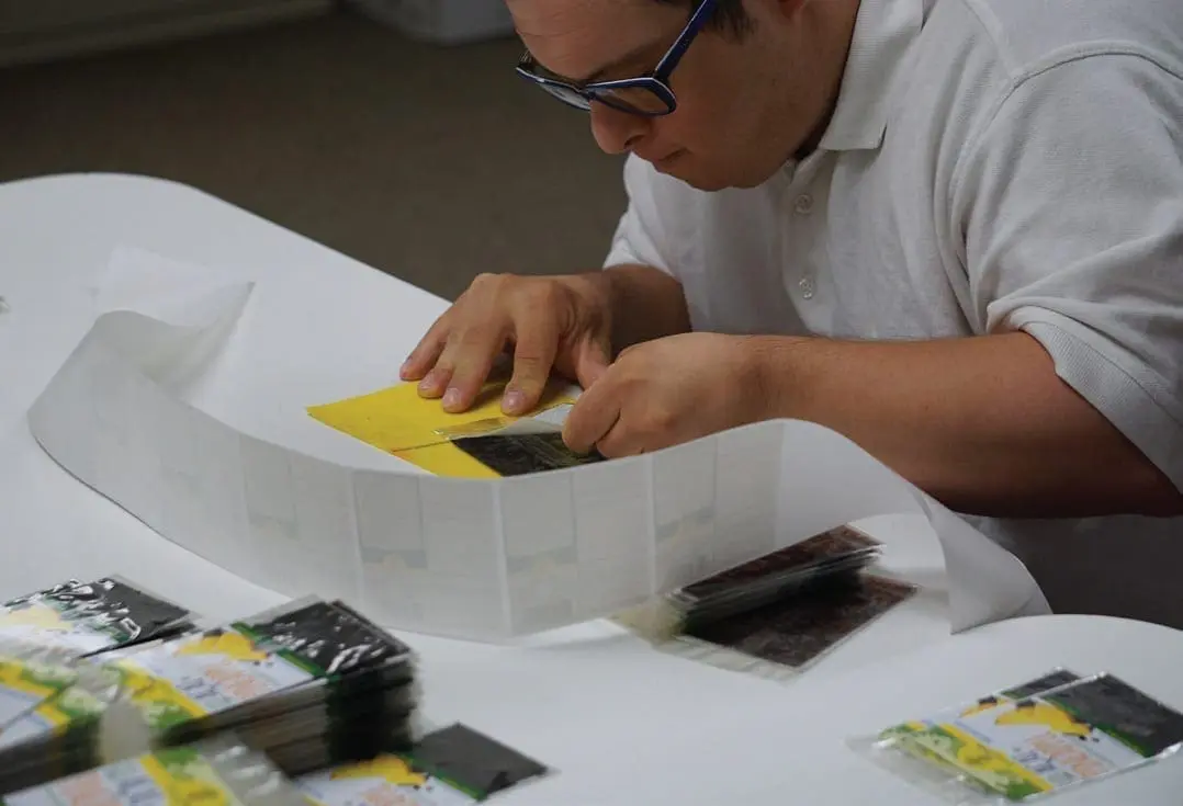Evan Delahanty placing fruit strips into packaging.