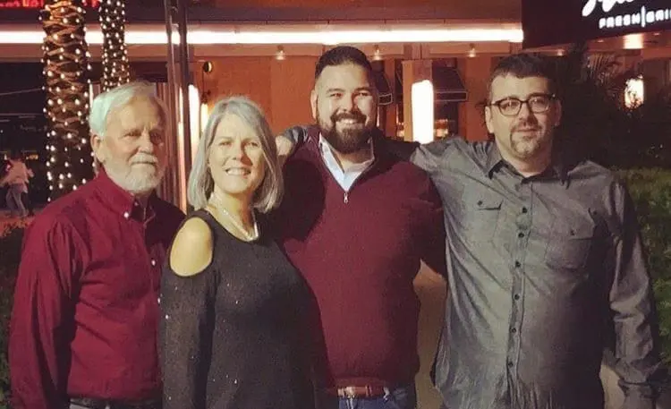 Howard, Sandy, Zachary, and Matthew Johnson stand together outdoors at night.
