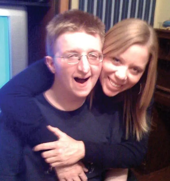 Liz Petruzzi hugs Joey Petruzzi from behind.