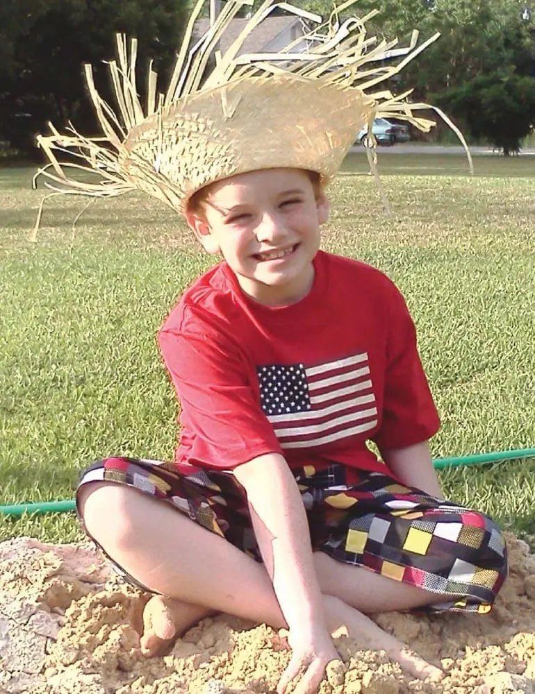 Ryan Carl Wasser wearing a straw hat and a red shirt with an American flag design.