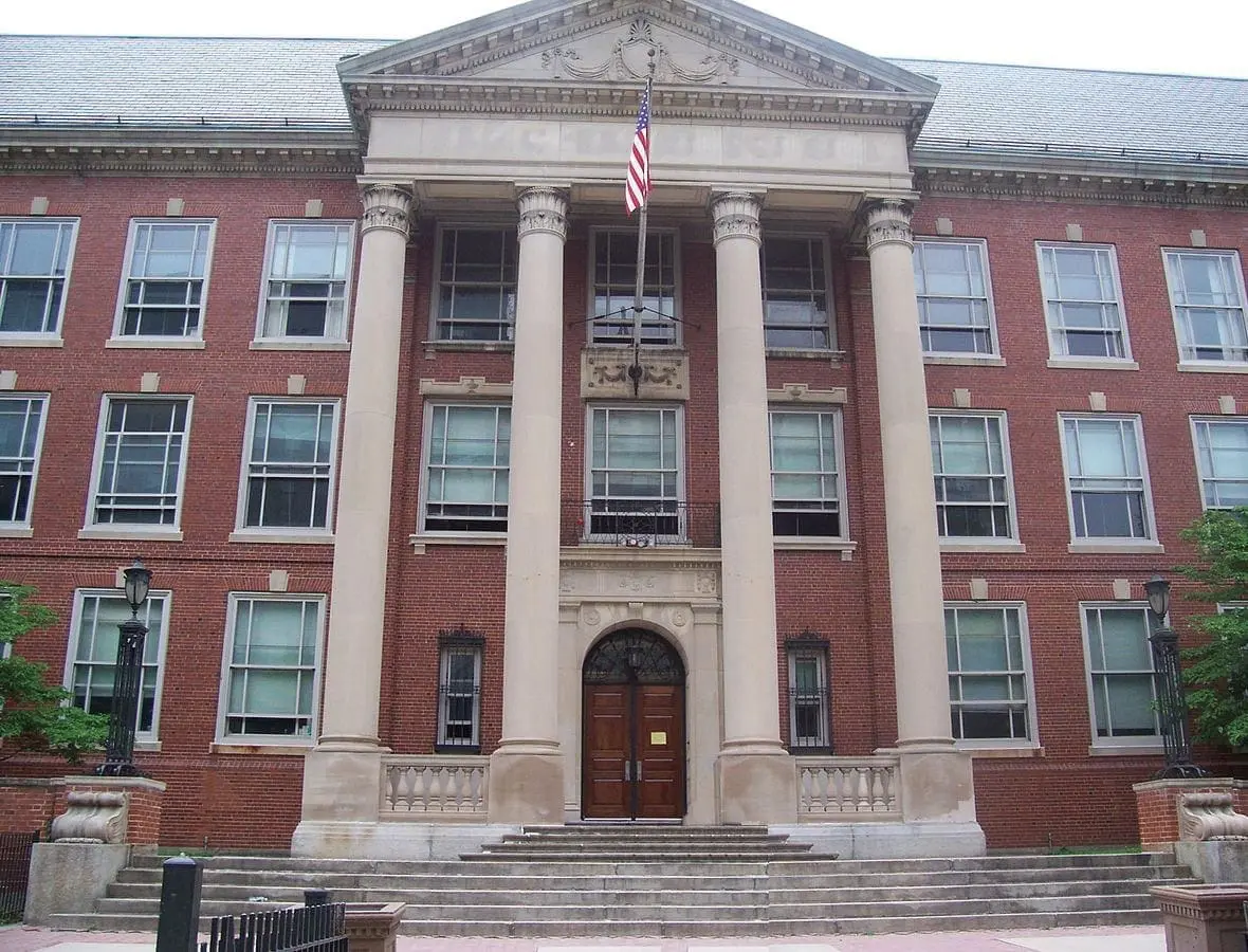 Brick school building with large columns and an American flag